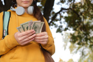 Young person outside counting cash