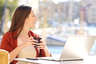 Woman at computer looking out a window