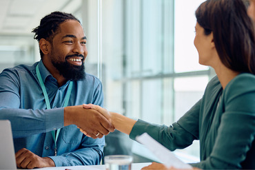 Man and woman shaking hands at a desk