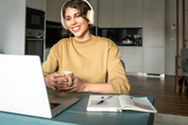 Woman at desk with headphone and laptop