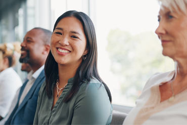 Smiling faces of several people attending a meeting