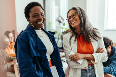 Two women smiling in group setting