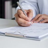Clipboard and paper with hand holding pen