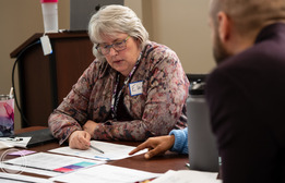 Close up of Elaine Scott reviewing documents at an ORS meeting