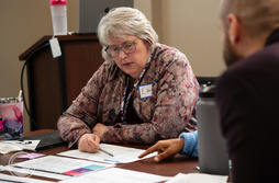 Close up of Elaine Scott reviewing documents at an ORS meeting