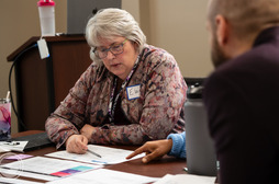 Close up of Elaine Scott reviewing documents at an ORS meeting