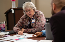 Close up of Elaine Scott reviewing documents at an ORS meeting