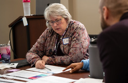 Close up of Elaine Scott reviewing documents at an ORS meeting