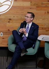 Justin speaking into the microphone