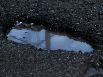 A pothole in the pavement filled with water