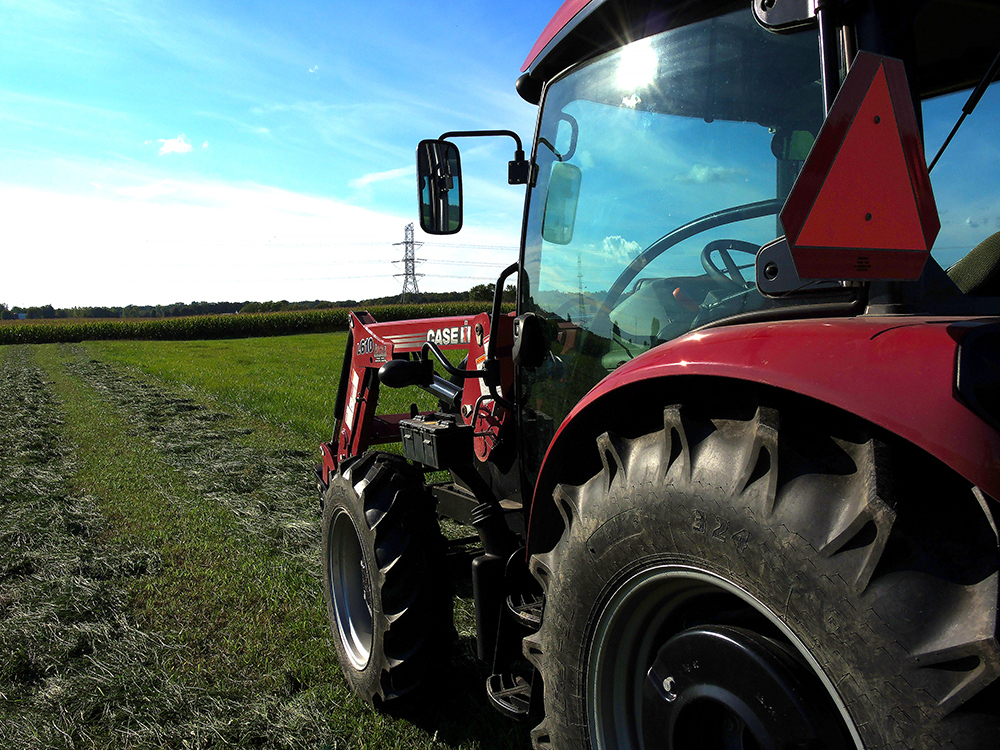 A tractor sits empty facing a mature Ottawa County cornfield in this file photo.