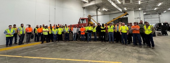 A group of Ottawa County Road Commission employees wearing bright yellow and orange safety vests