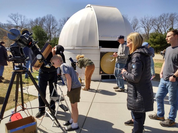 Kid looking through telescope at the observatory