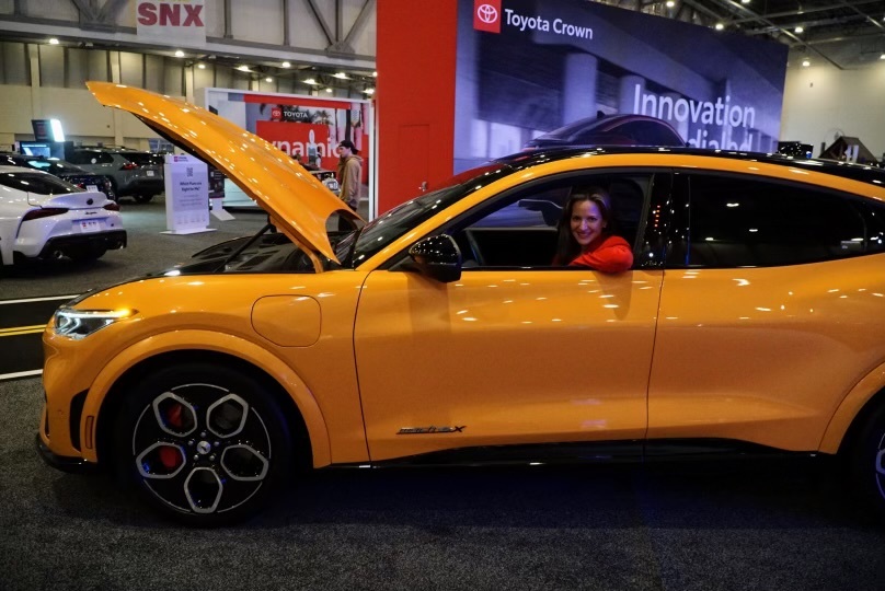 Secretary Benson sitting in vehicle at Michigan International Auto Show 2023 in Grand Rapids 