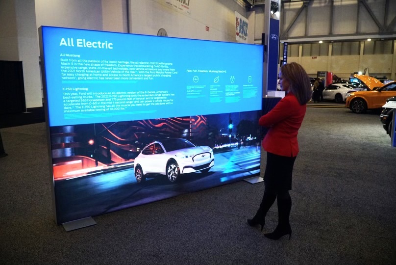 Secretary Benson reads about electric vehicle technology at the 2023 Michigan International Auto Show in Grand Rapids 