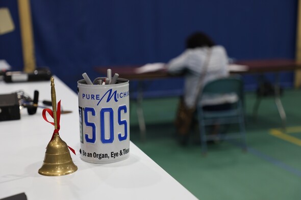 A bell with a ribbon is rung when a clinic participant has their license restored; a woman in Sault Ste. Marie takes the written driver's test