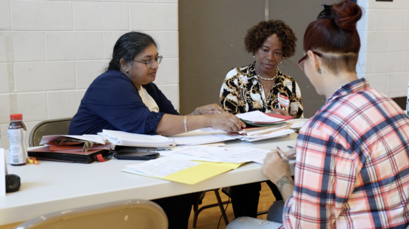 Clinic volunteers meet with Road to Restoration clinic participant 