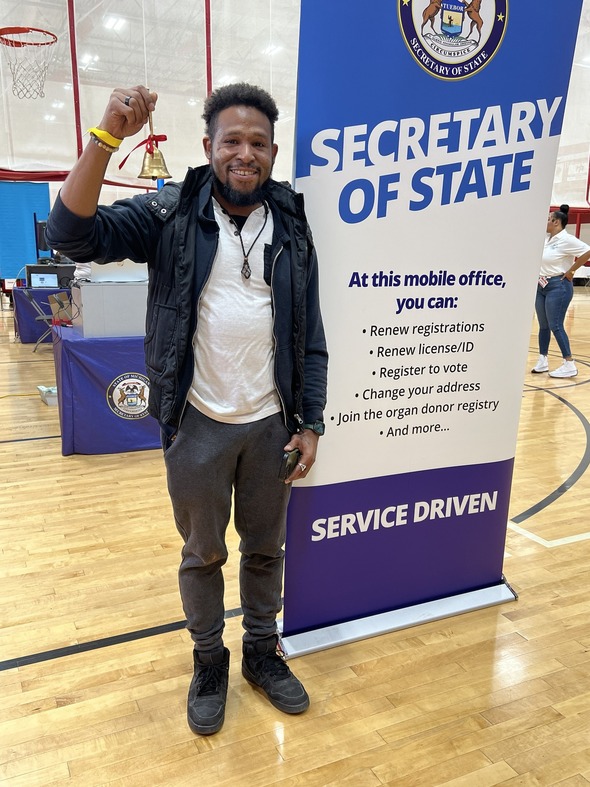 David Nelson of Detroit rings bell after his driver's license is restored 