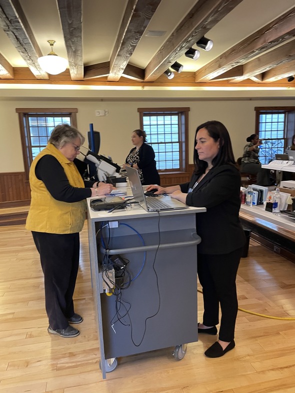 Secretary of State mobile office staff assist Mackinac Island Mayor Margaret Doud (L) with her license plate and driver's license renewal. 