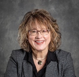 Jeannie Krull, a white woman with wavy blonde hair and glasses