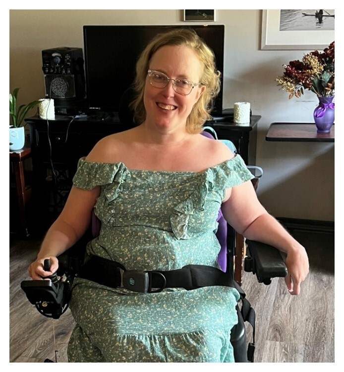 Lauren Ireland, a woman with blonde hair and a green dress in her motorized wheelchair
