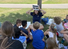 teacher holding a photo of bees for students to see