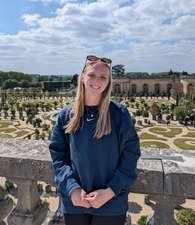 Photo of female person on a terrace in front of a garden