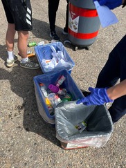 Three tubs sitting on pavement with sorted materials