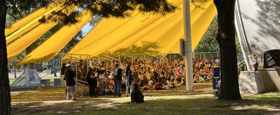 Students sit under a yellow awning listening to the Minnesota Science Museum's show WATER!