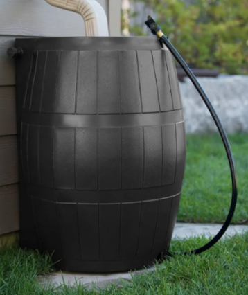 Black rain barrel with downspout from house