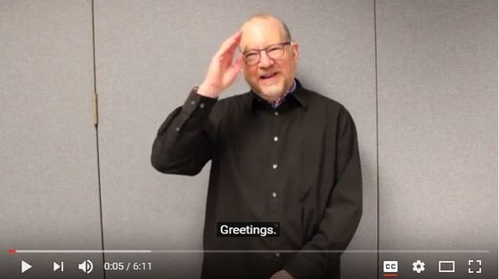 Screen shot from the DHHSD bill vlog with David Rosenthal. He is signing, "hello."