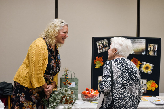 Two women conversing at a booth at the 55+ expo