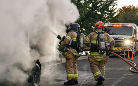 Two firefighters putting out a demo fire