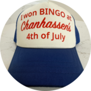 Blue and white trucker hat reading “I won BINGO at Chanhassen’s 4th of July” sits on a light countertop.