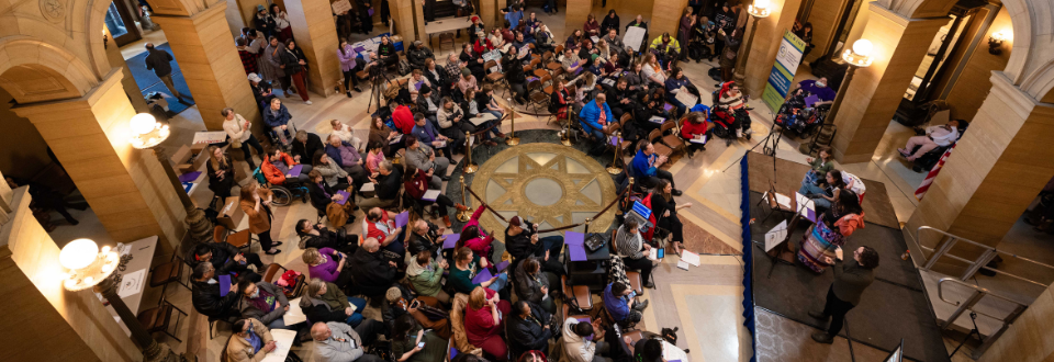 A large group of people are gathered at the Capitol Rotunda for a rally.