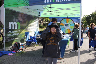 child smiling outside the commerce booth at a public event
