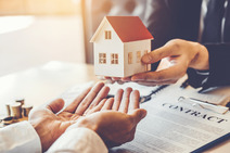 hands receiving a small house