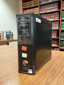 Image of Minnesota Litigation Forms Deskbook in front of a bookshelf