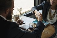Two people shaking hands at a table