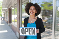 Woman holding open for business sign