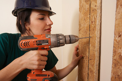 Worker using a drill in a construction project