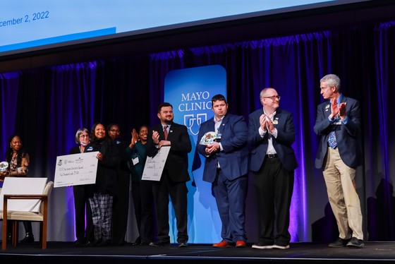 Walleye Tank Winner accepts giant check on stage for winning startup competition