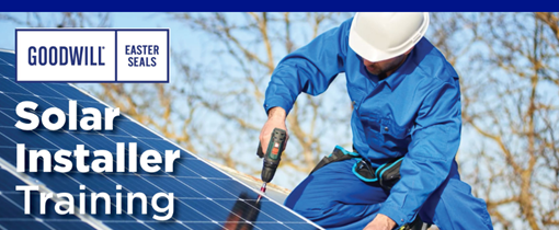 Man in a blue jumpsuit wearing a white hard hat installing a solar panel