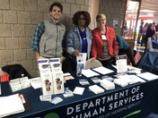 Three DHS staff members staff a booth at the Deaf Awareness Day Fair