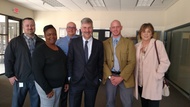 Five DHS staff pose with Commissioner Lourey in an office space at Metro Resources.