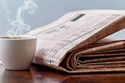 newspaper beside a coffee cup