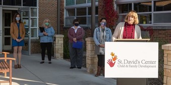 Commissioner Harpstead speaks at a podium at St. David's Center for child and family development