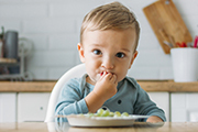 young boy eating grapes in the kitchen
