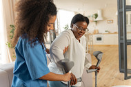 DSP employee-owned cooperative grants - stock photo of a person helping an older adult using walking aids