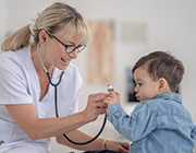 Stock photo of a doctor showing a little boy their stethoscope